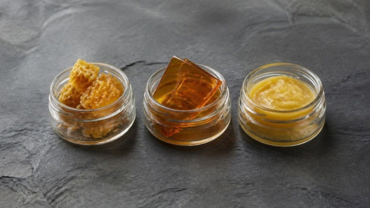 Trois petits pots en verre ouverts sur une ardoise : extrait friable, plaque ambrée translucide et pâte dorée crémeuse, article du Journal Calm&Co